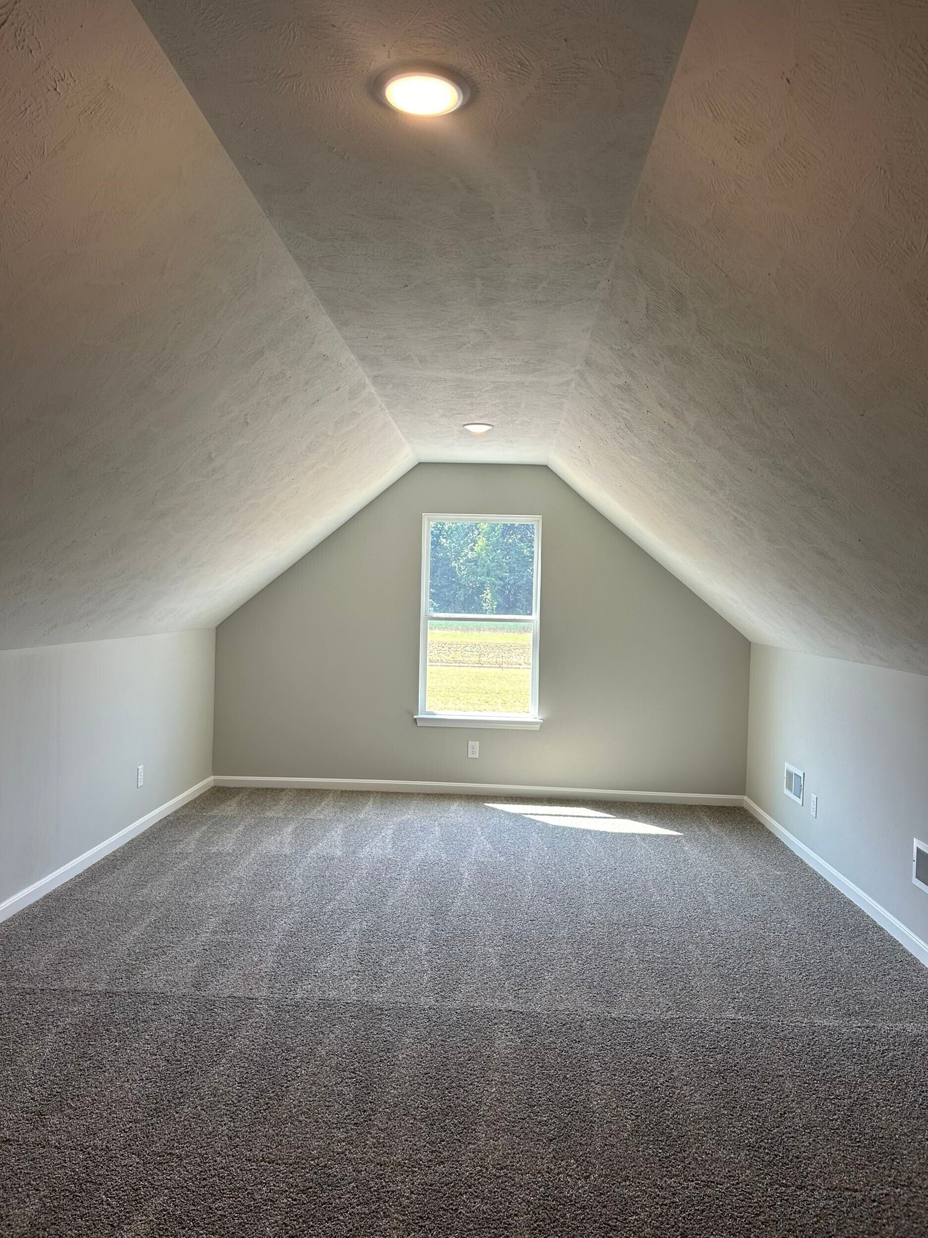 Evansville, IN attic room with a sloped ceiling and gray carpet