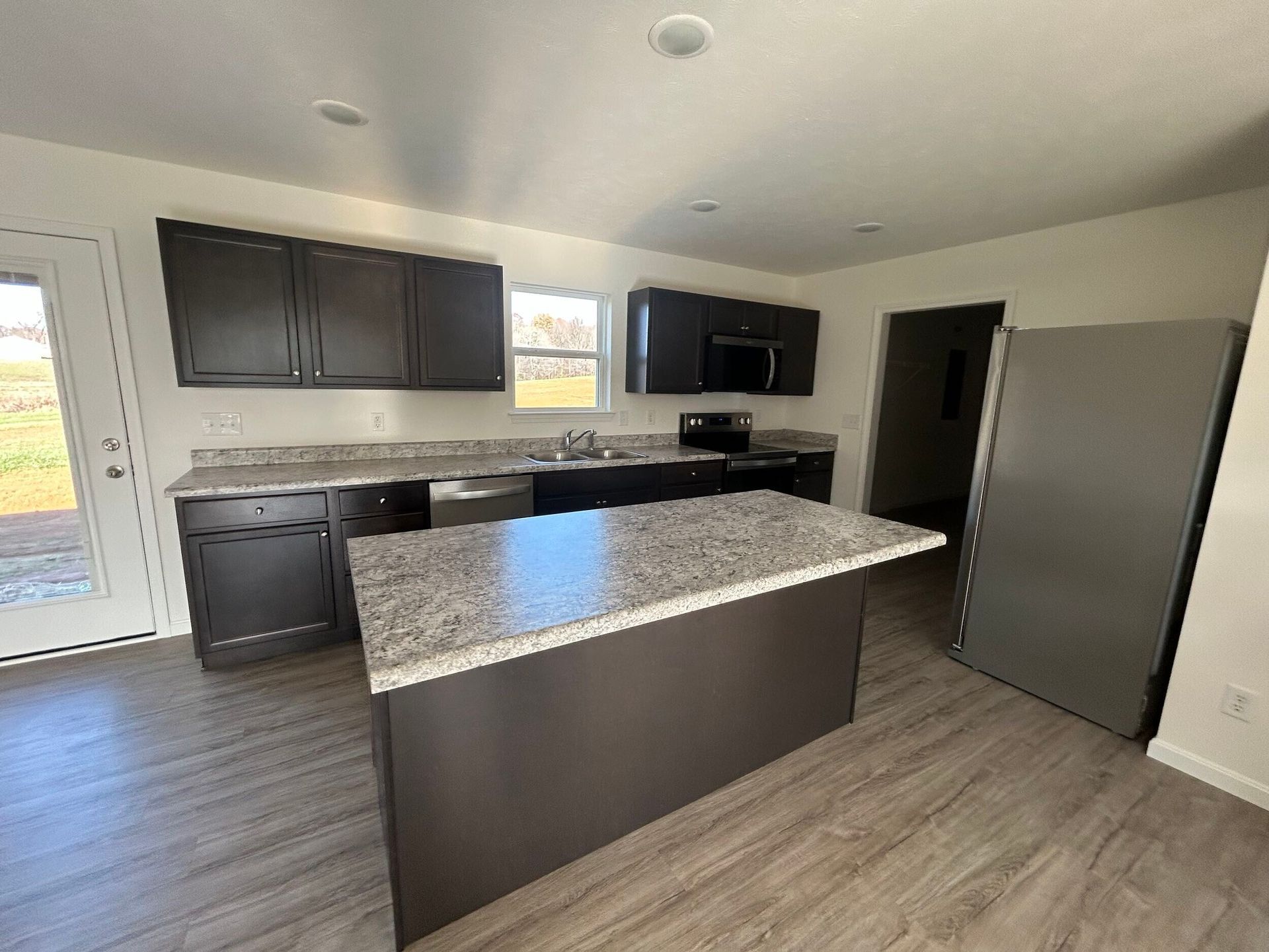 Evansville, IN kitchen with an island and a gray luxury vinyl plank floor