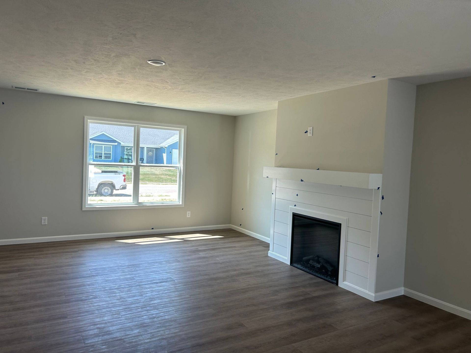 Evansville, IN living room with a white shiplap fireplace and a brown luxury vinyl plank floor